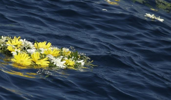 Fiori buttati in mare per i migranti vittime della strage del 3 ottobre 2013