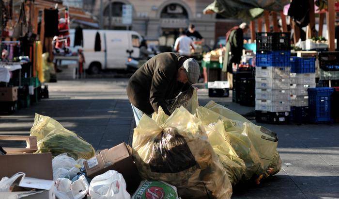 Un anziano fruga tra i rifiuti del mercato di piazza S. Cosimato a Trastevere