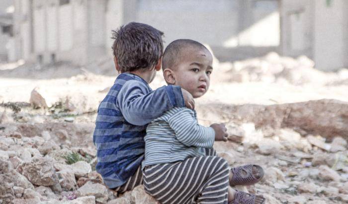 Due bambini tra le macerie di un bombardamento