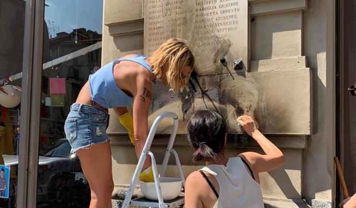 Torino antifa: volontari ripuliscono la lapide dei partigiani bruciata dai vandali fascisti