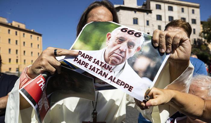 Tra i negazionisti c'è anche chi brucia la foto di Papa Francesco