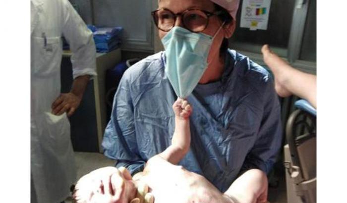 Il neonato che si aggrappa alla mascherina all'ostetrica: ecco la foto simbolo nell'anno della pandemia
