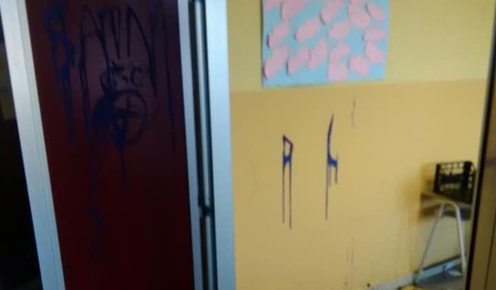 Novara, vandali minorenni danneggiano una scuola: distrutti alcuni crocifissi, scritte sataniche sui muri